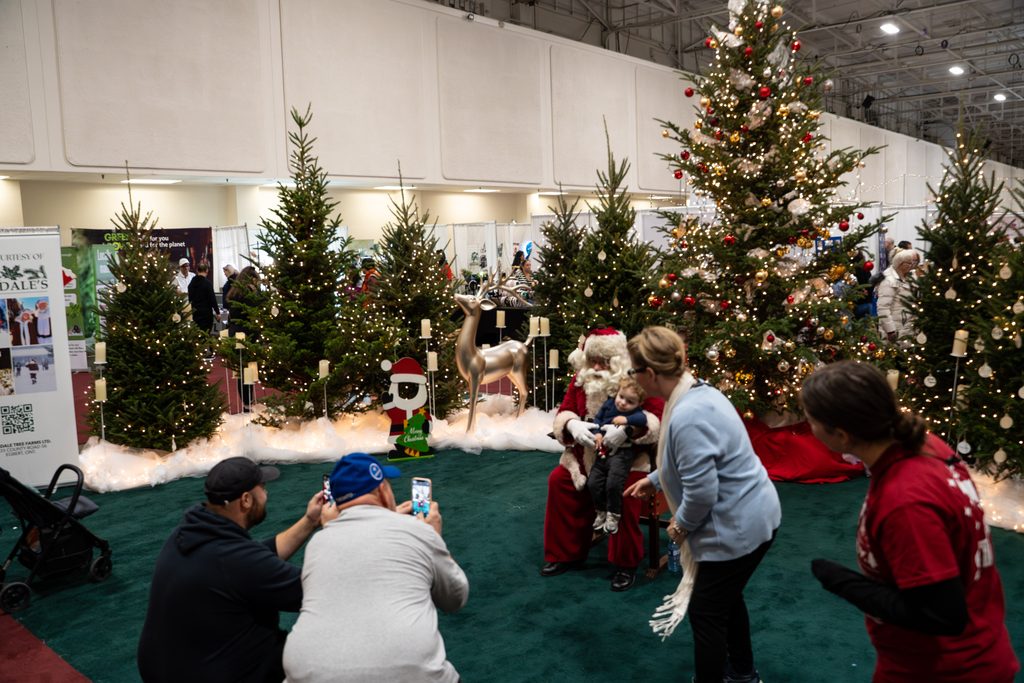 Seasons Christmas Show Santa Posing With Kid in North Pole Feature Area